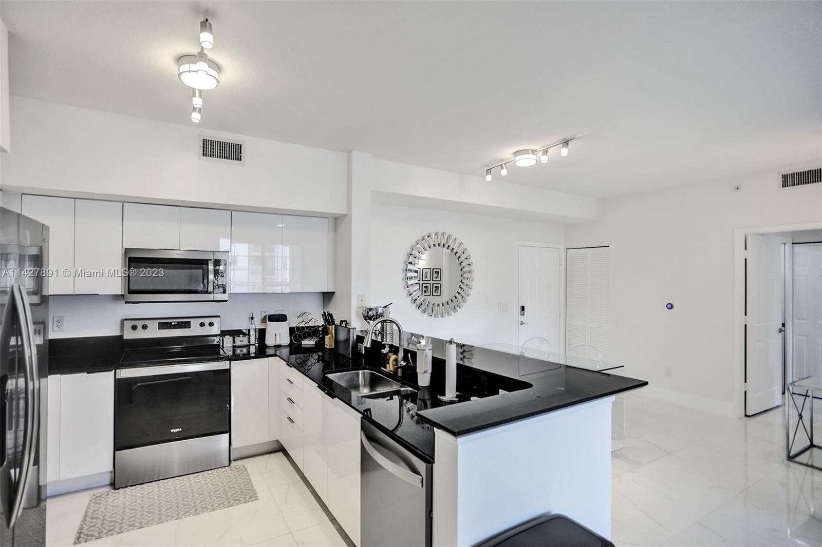 233 South Federal Highway, Unit 605 Boca Raton, FL 33432 - Photo 10 of 41 a kitchen with a sink a stove and cabinets