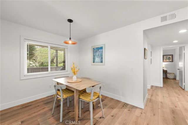 a dining room with furniture window and wooden floor