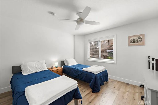 a bedroom with two beds and painting on the wall