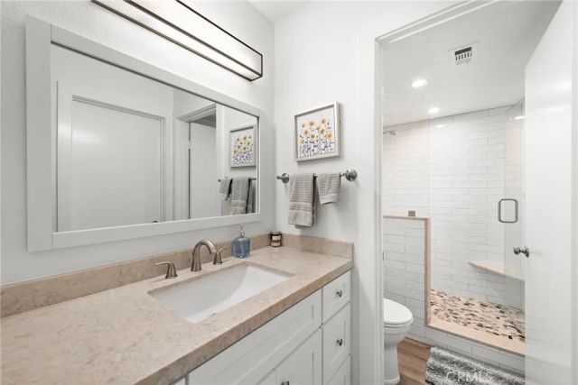 a bathroom with a sink a toilet and shower