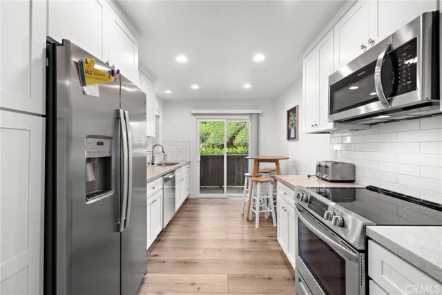 a kitchen with stainless steel appliances granite countertop a stove a refrigerator and a microwave