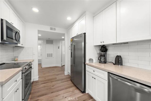 a kitchen with stainless steel appliances a sink stove and refrigerator