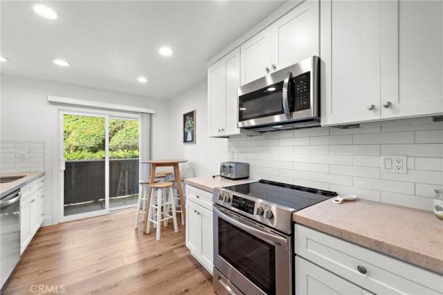a kitchen with stainless steel appliances a stove microwave and sink