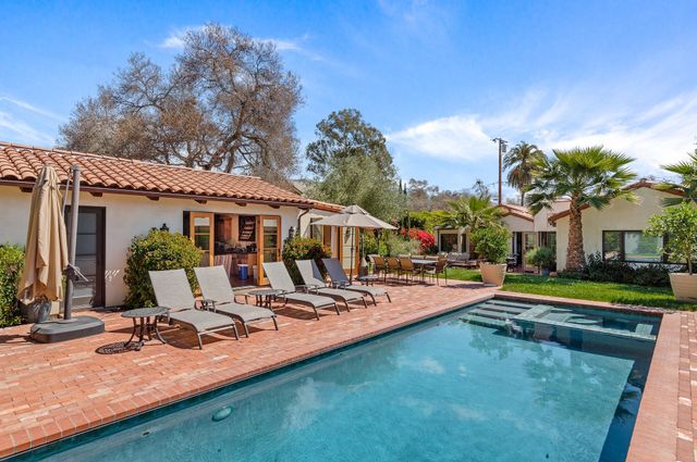 a view of a house with swimming pool and sitting area
