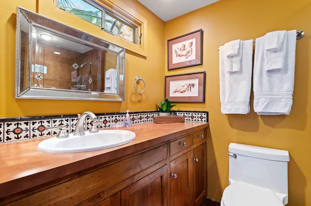 a bathroom with a toilet sink and mirror