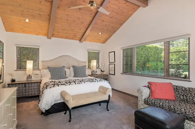 a spacious bedroom with a bed couch and window