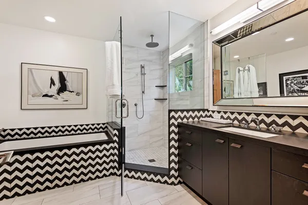 a bathroom with a sink a mirror and a shower