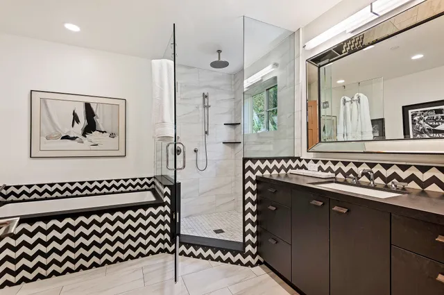 a bathroom with a sink a mirror and a shower