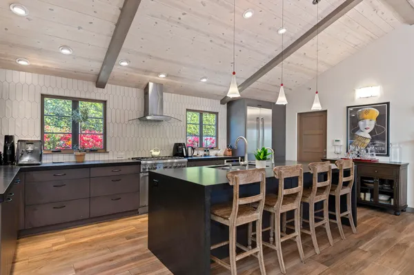 a large kitchen with lots of counter space and dining table