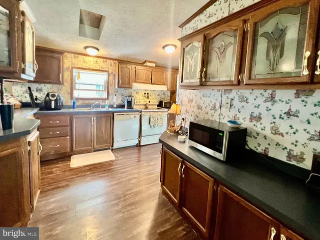 a kitchen with stainless steel appliances kitchen island granite countertop a stove a sink and a microwave