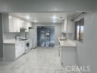 a large white kitchen with a sink and cabinets