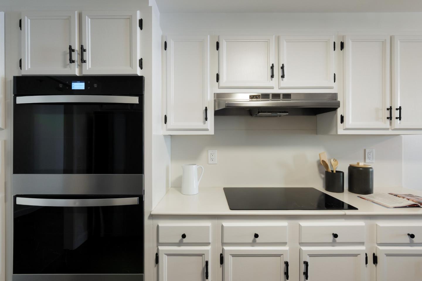110 Park Road, Unit 202 Burlingame, CA 94010 - Photo 3 of 31 a kitchen with white cabinets and black appliances