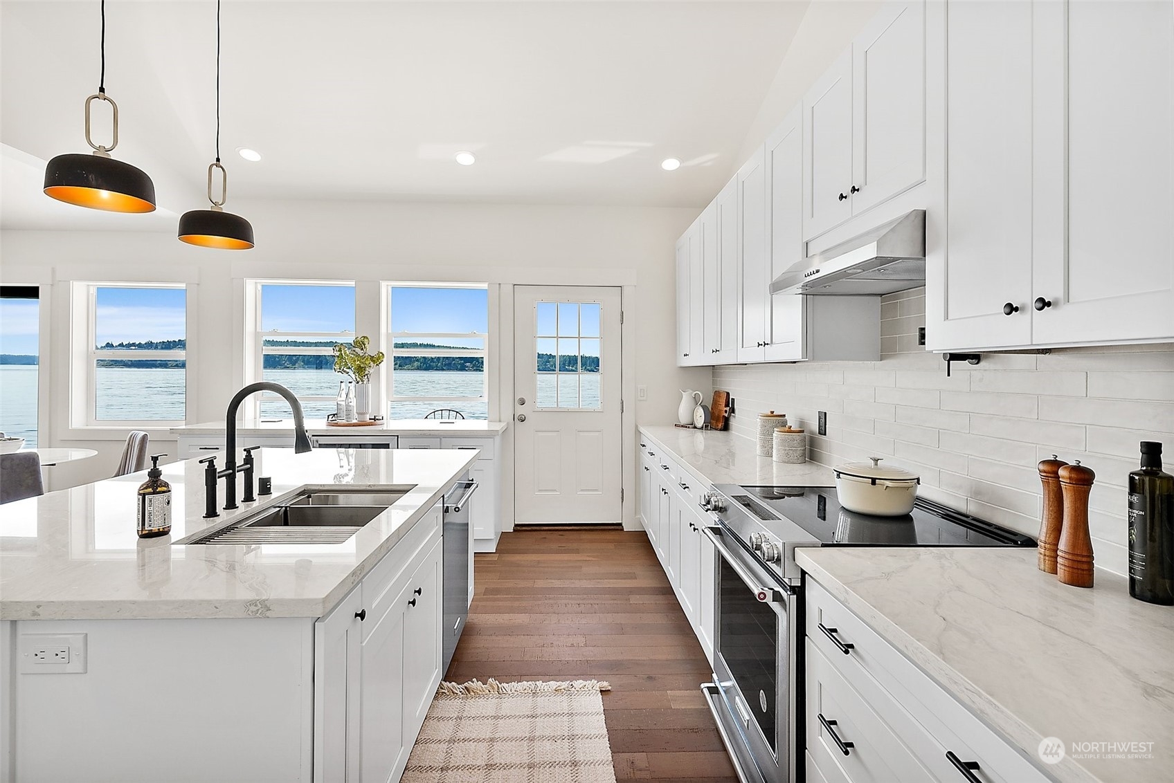 4436 Sunset Beach Road West University Place, WA 98466 - Photo 10 of 33 a kitchen with stainless steel appliances granite countertop a sink a stove and a wooden floors