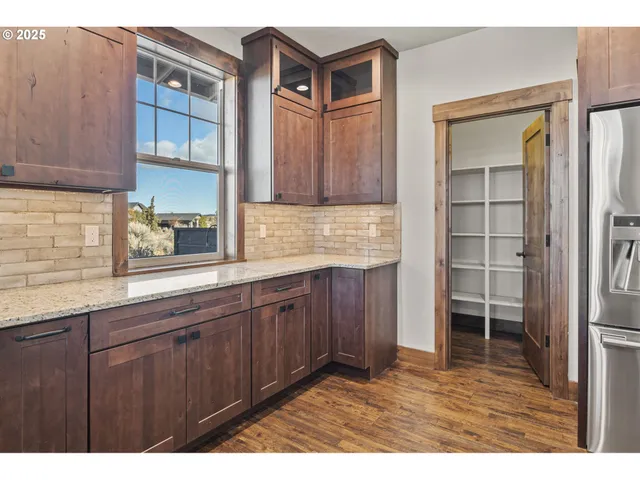 a kitchen with cabinets wooden floor and a window