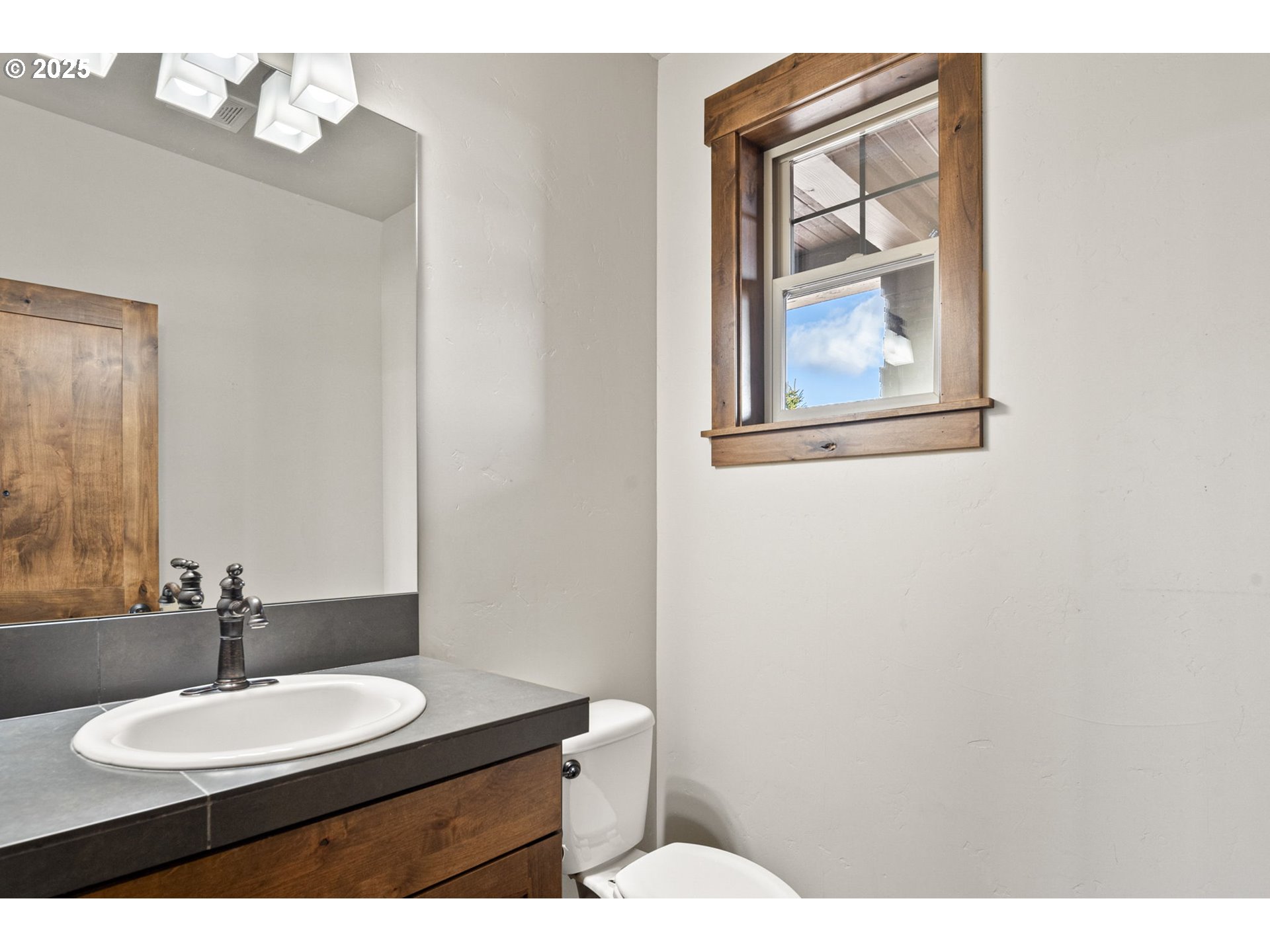 16660 Southwest Ranchview Court Powell Butte, OR 97753 - Photo 17 of 32 a bathroom with a toilet a sink and mirror