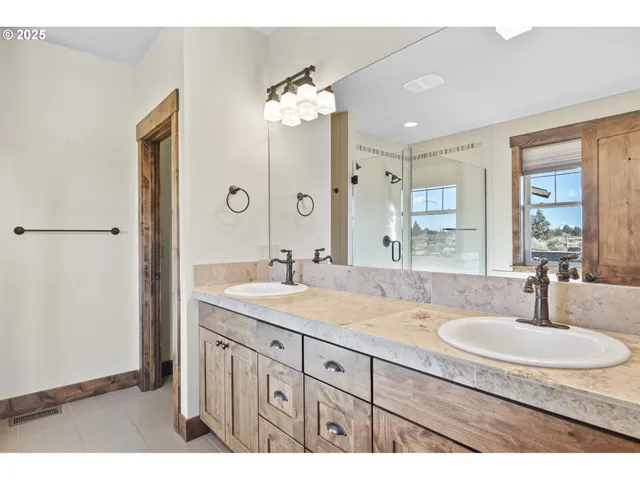 a bathroom with a granite countertop sink a large mirror and a shower