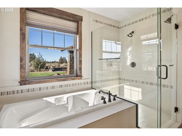 a bathroom with a tub a sink and glass door