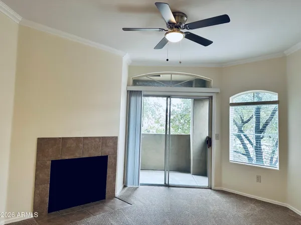 a view of an empty room with a fireplace and a window
