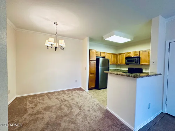 a view of a kitchen with stainless steel appliances granite countertop a refrigerator and a stove top oven