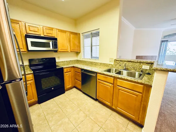 a kitchen with stainless steel appliances a stove a sink and a refrigerator