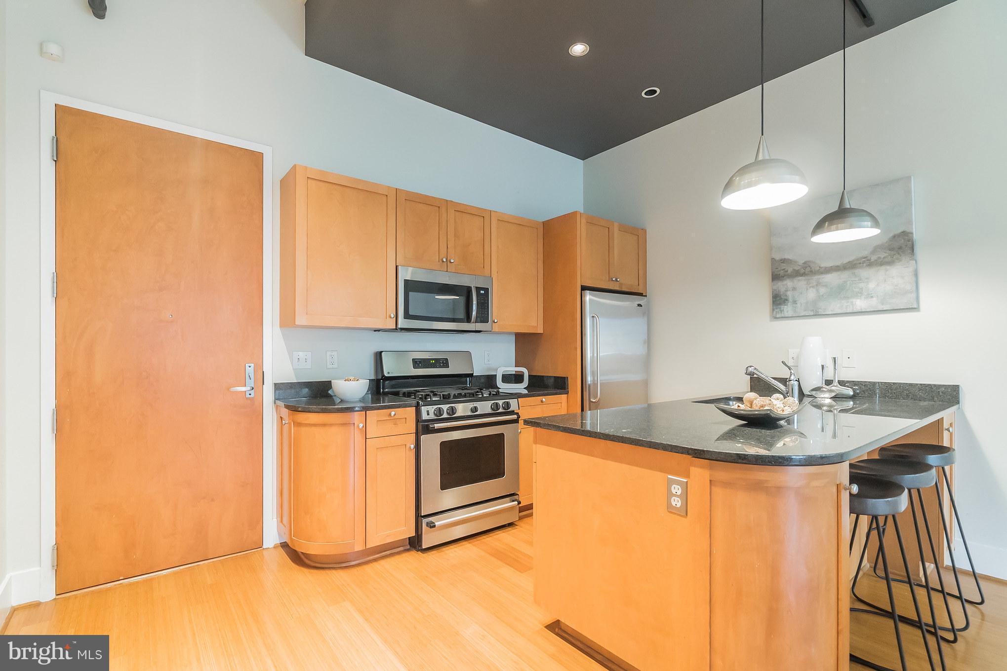 2328 Champlain Street Northwest, Unit 329 Washington, DC 20009 - Photo 4 of 25 a kitchen with stainless steel appliances a sink stove and refrigerator