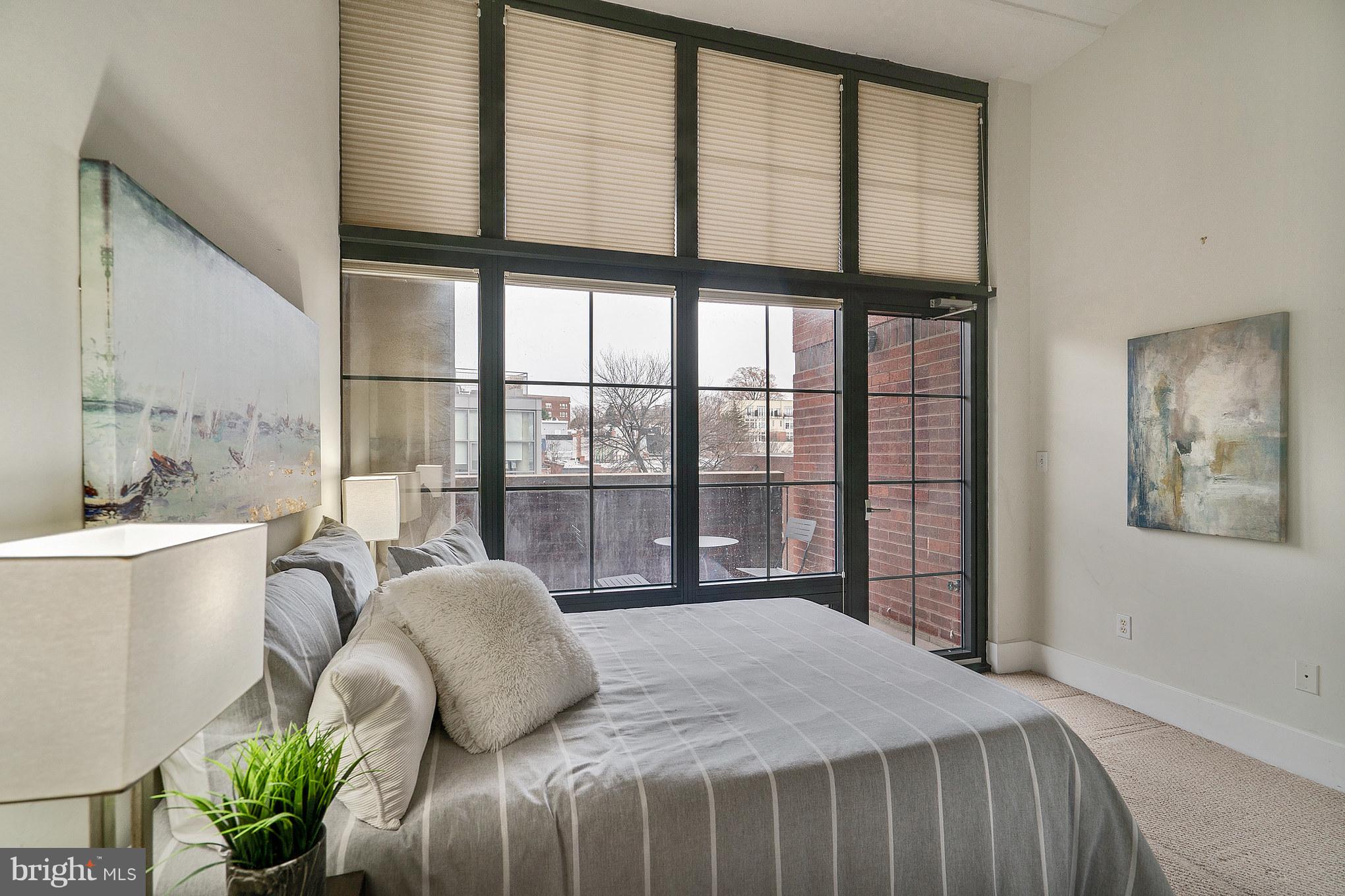 2328 Champlain Street Northwest, Unit 329 Washington, DC 20009 - Photo 8 of 25 a bedroom with a large bed and a large window