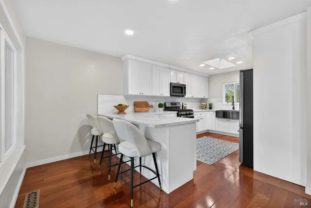 a kitchen with stainless steel appliances granite countertop a sink a stove and cabinets