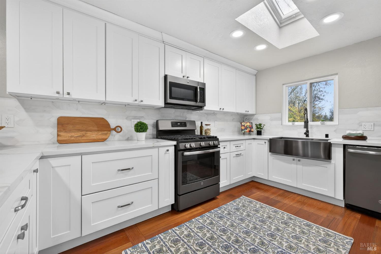 4933 Hansen Drive Santa Rosa, CA 95409 - Photo 19 of 58 a kitchen with granite countertop white cabinets and stainless steel appliances