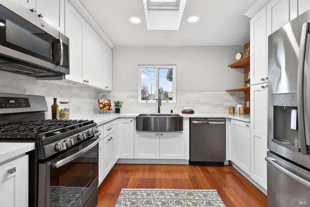 a kitchen with stainless steel appliances a refrigerator and a stove top oven