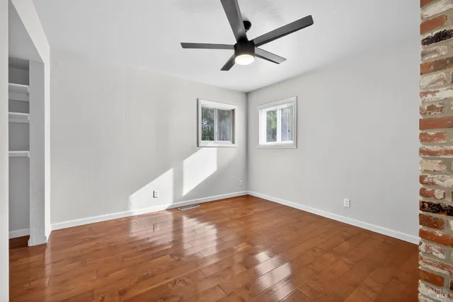 a bedroom with a large bed and a ceiling fan