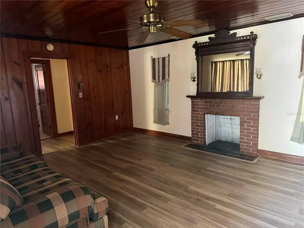 a view of a livingroom with wooden floor and a fireplace