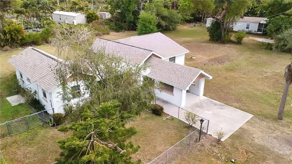 an aerial view of a house with a yard and trees