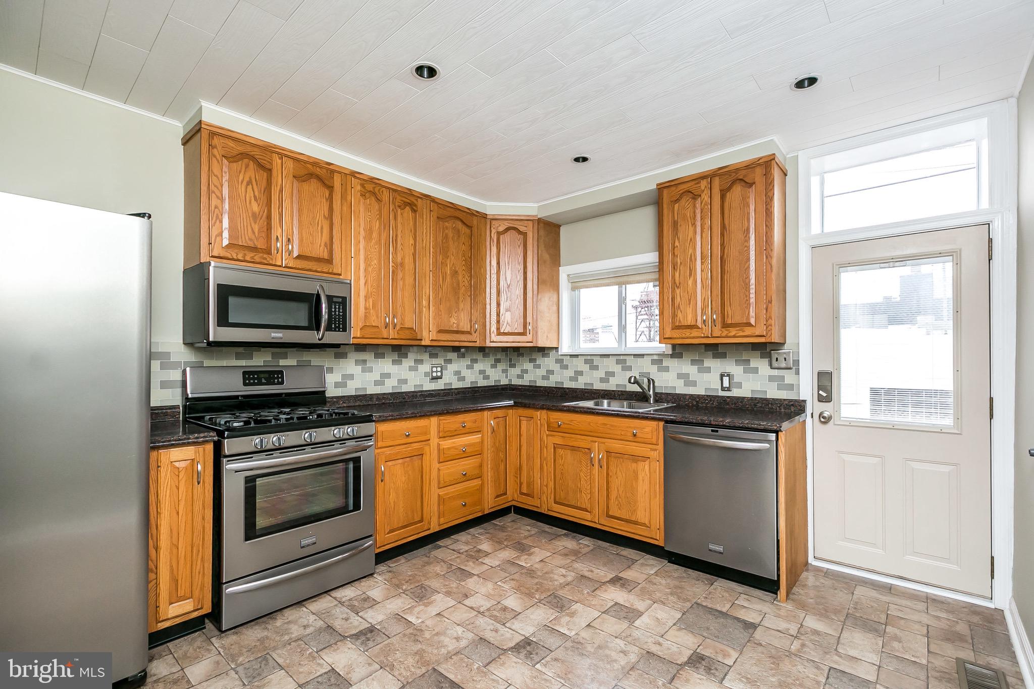 1315 Webster Street Baltimore, MD 21230 - Photo 11 of 29 a kitchen with granite countertop stainless steel appliances a stove sink and microwave