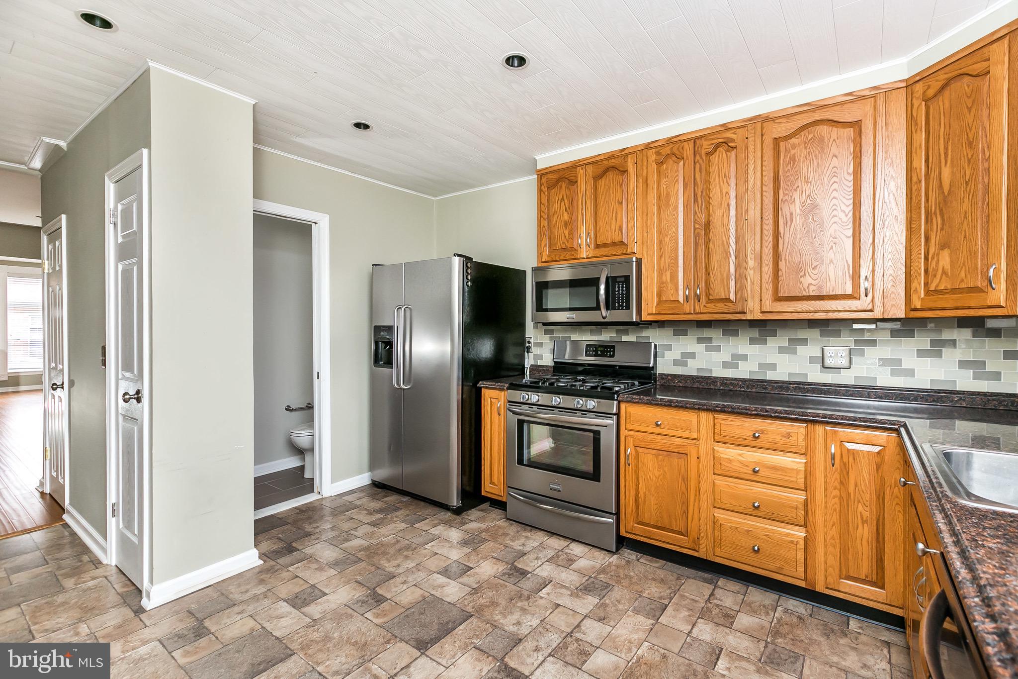 1315 Webster Street Baltimore, MD 21230 - Photo 13 of 29 a kitchen with stainless steel appliances granite countertop a refrigerator and cabinets