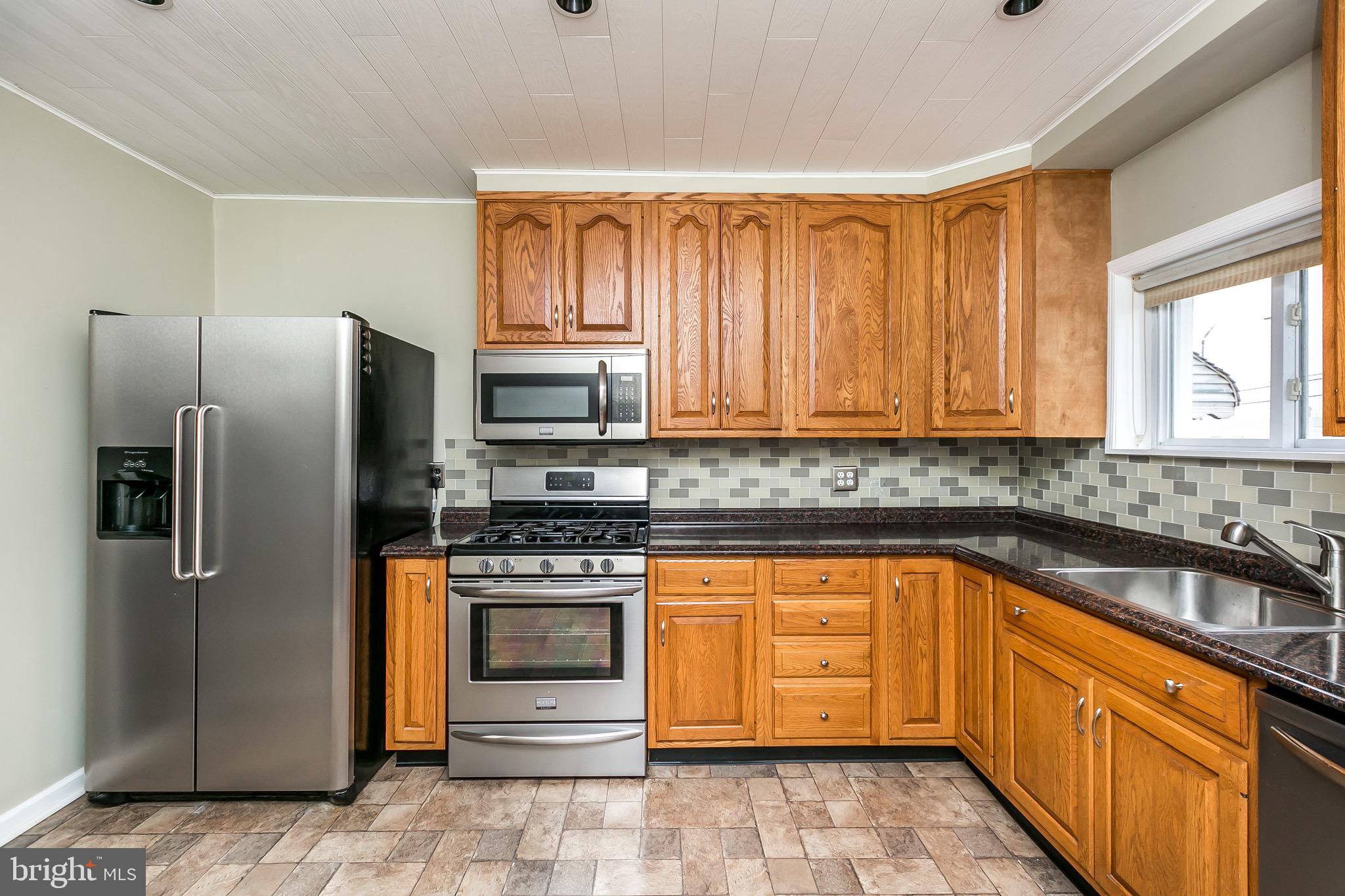 1315 Webster Street Baltimore, MD 21230 - Photo 15 of 29 a kitchen with stainless steel appliances granite countertop a stove a sink dishwasher and a refrigerator