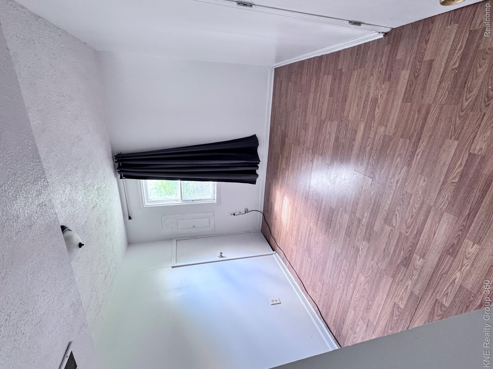 4928 Hughes Road Lansing, MI 48910 - Photo 6 of 35 Wood-finish flooring throughout, complemented by white walls