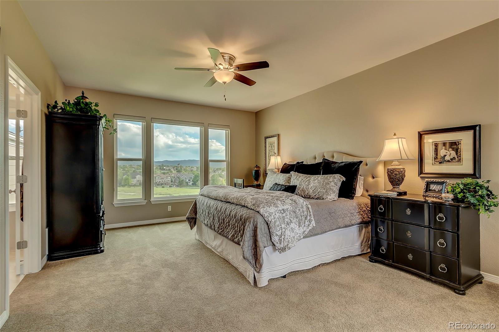 456 West Angus Way Highlands Ranch, CO 80129 - Photo 23 of 40 a spacious bedroom with a bed and a chandelier