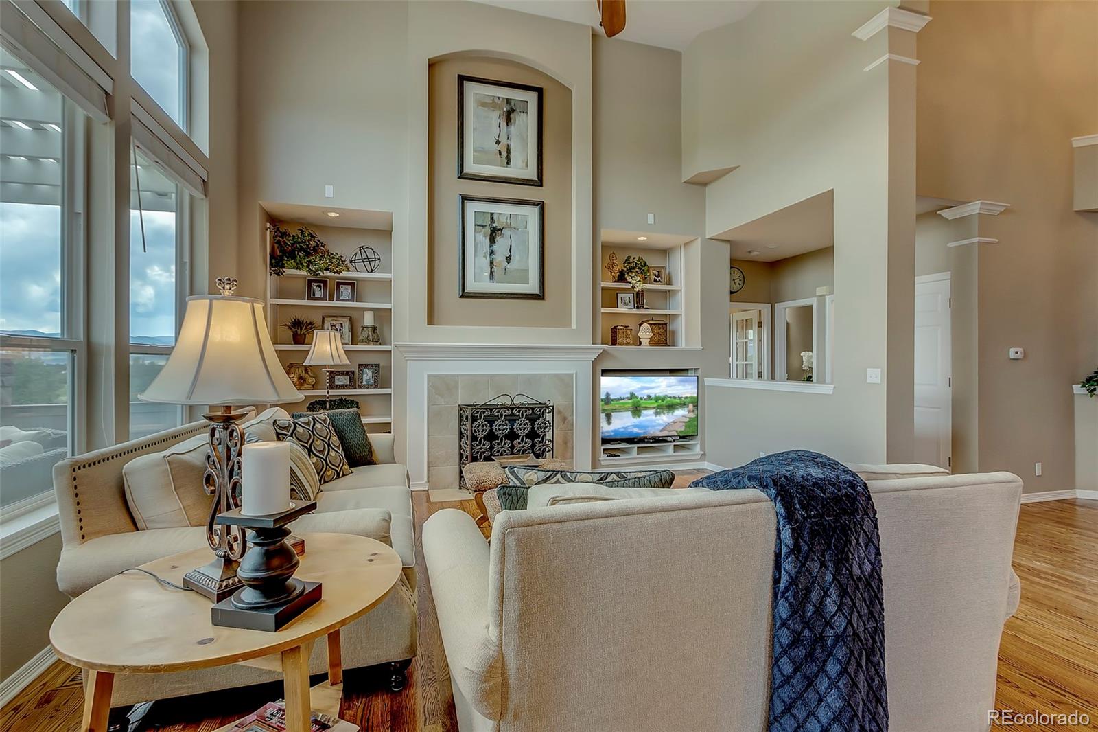 456 West Angus Way Highlands Ranch, CO 80129 - Photo 8 of 40 a living room with furniture a fireplace and a table
