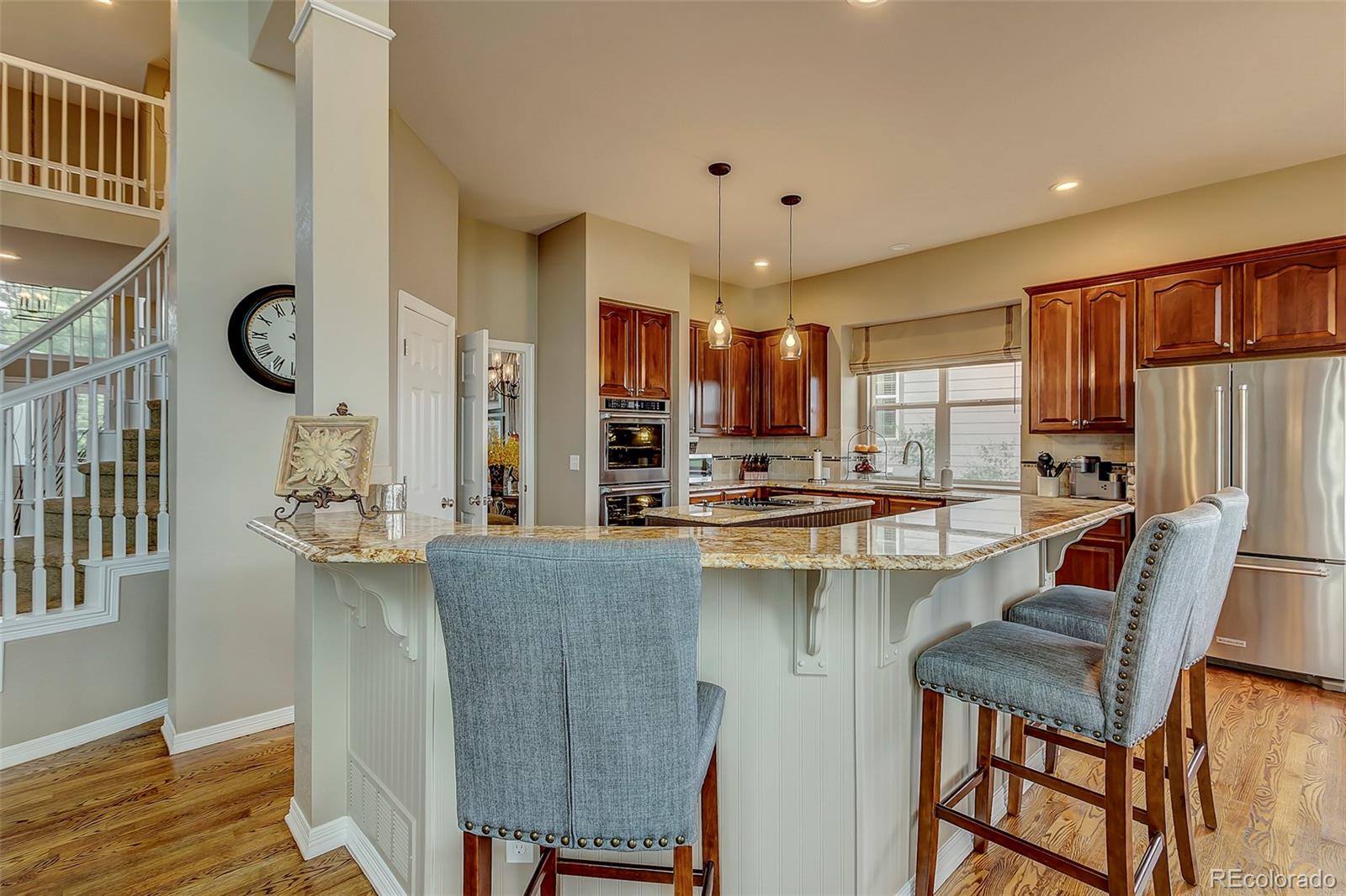 456 West Angus Way Highlands Ranch, CO 80129 - Photo 10 of 40 a kitchen with stainless steel appliances granite countertop a refrigerator and a stove top oven