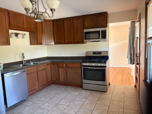 a kitchen with stainless steel appliances granite countertop a stove and a microwave