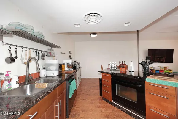 a kitchen with granite countertop a sink and a stove top oven