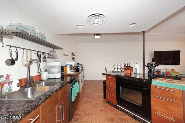 a kitchen with granite countertop a sink and a stove top oven