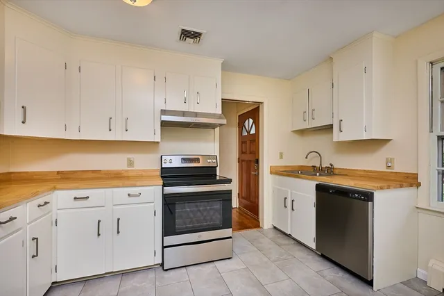 a kitchen with cabinets stainless steel appliances and sink
