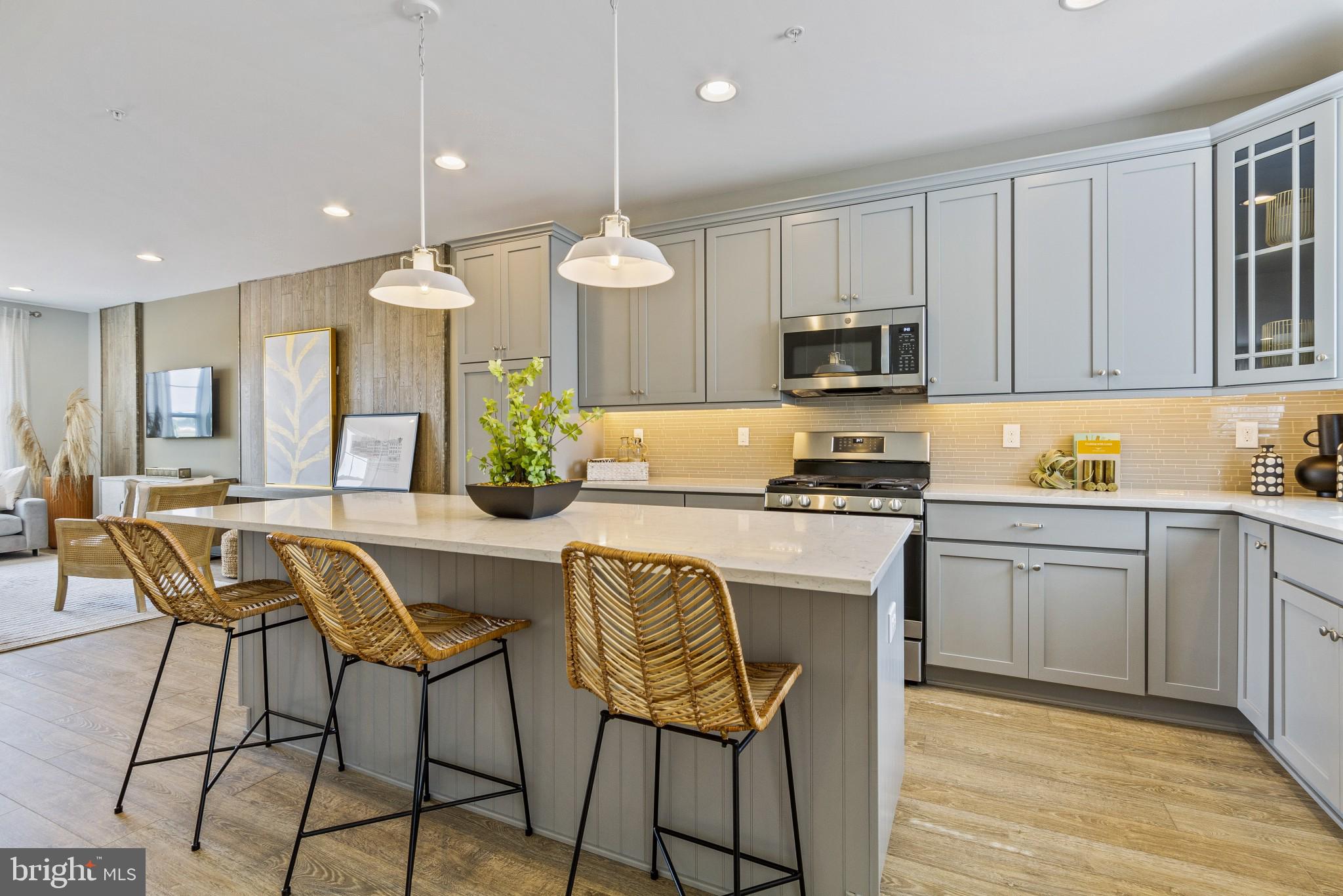 2 Jameson Way, Unit BASE Chalfont, PA 18914 - Photo 14 of 34 a kitchen with stainless steel appliances granite countertop a stove a sink a microwave a island with a dining table and chairs