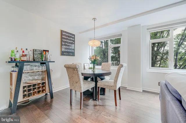 a dining room with furniture a chandelier and wooden floor