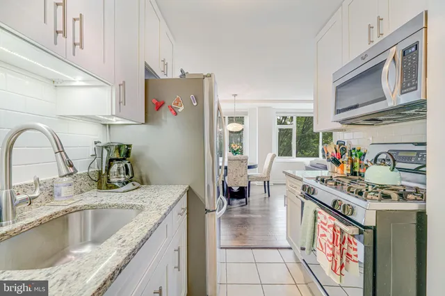a kitchen with stainless steel appliances granite countertop a sink stove and cabinets