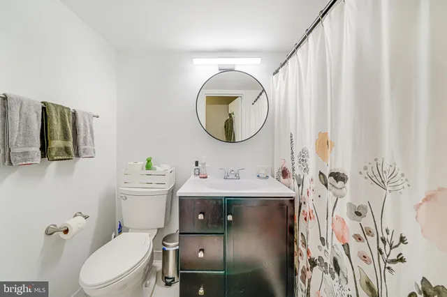 a bathroom with a toilet sink vanity tub and mirror