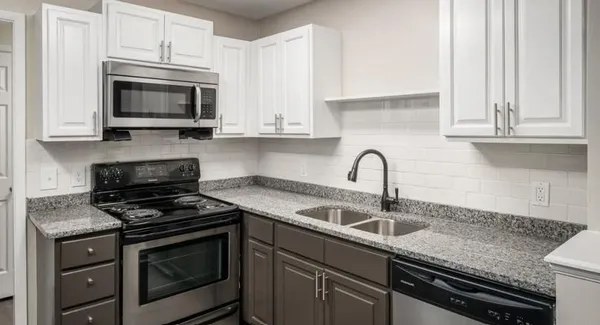 a kitchen with granite countertop white cabinets and appliances