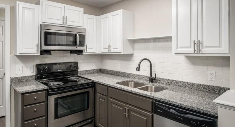 a kitchen with granite countertop white cabinets and appliances