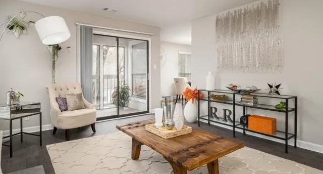 a living room with furniture a rug and a table